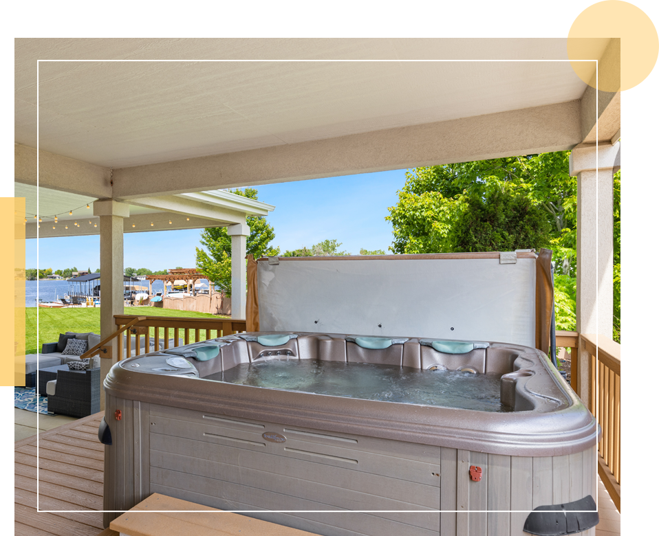 A hot tub is shown on the deck of a house.